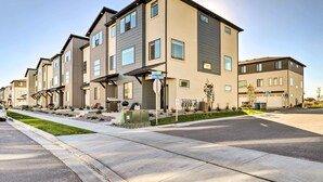A modern apartment building with multiple units, a covered parking area, and a well-maintained lawn. - Modern Townhome - 8 Mi to Thanksgiving Point! (American Fork)