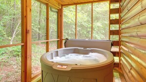 A hot tub in a wooden cabin with large windows overlooking a forest. - Hot Tub Soaks! 'moonshine Manor' Near Lake Lure (Lake Lure)