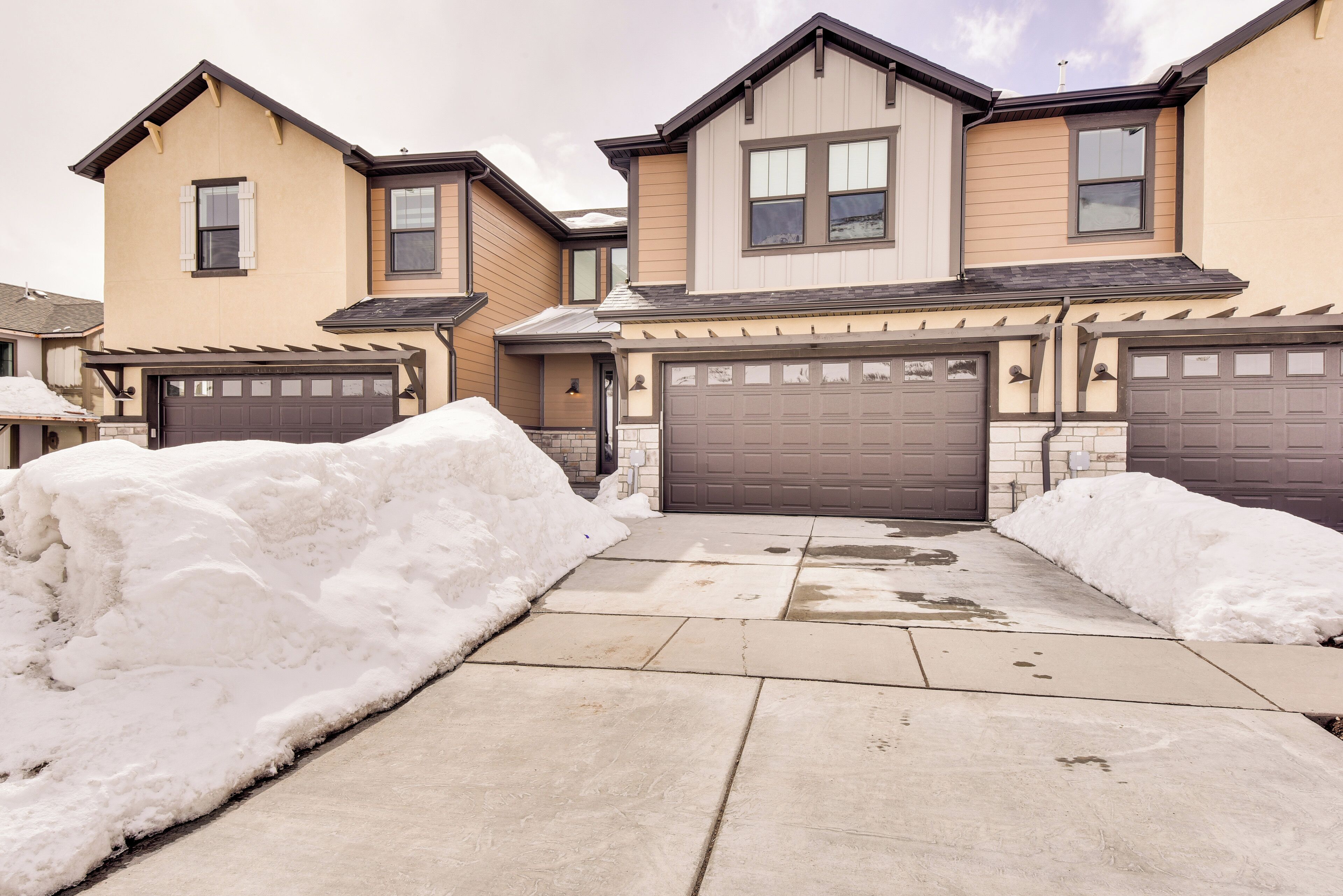 A residential area with two houses, each with a garage and a driveway.