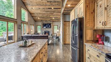 A spacious kitchen with a large island, wooden cabinets, and a built-in TV.