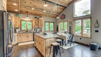 A spacious kitchen with wooden cabinets, a large island, and ample natural light from the windows.