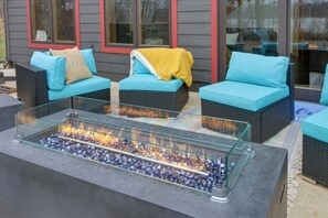 A glass-top fire feature with seating on either side. - Modern Lakeside Chalet on Crow Wing Chain w/ Dock! (Nevis)