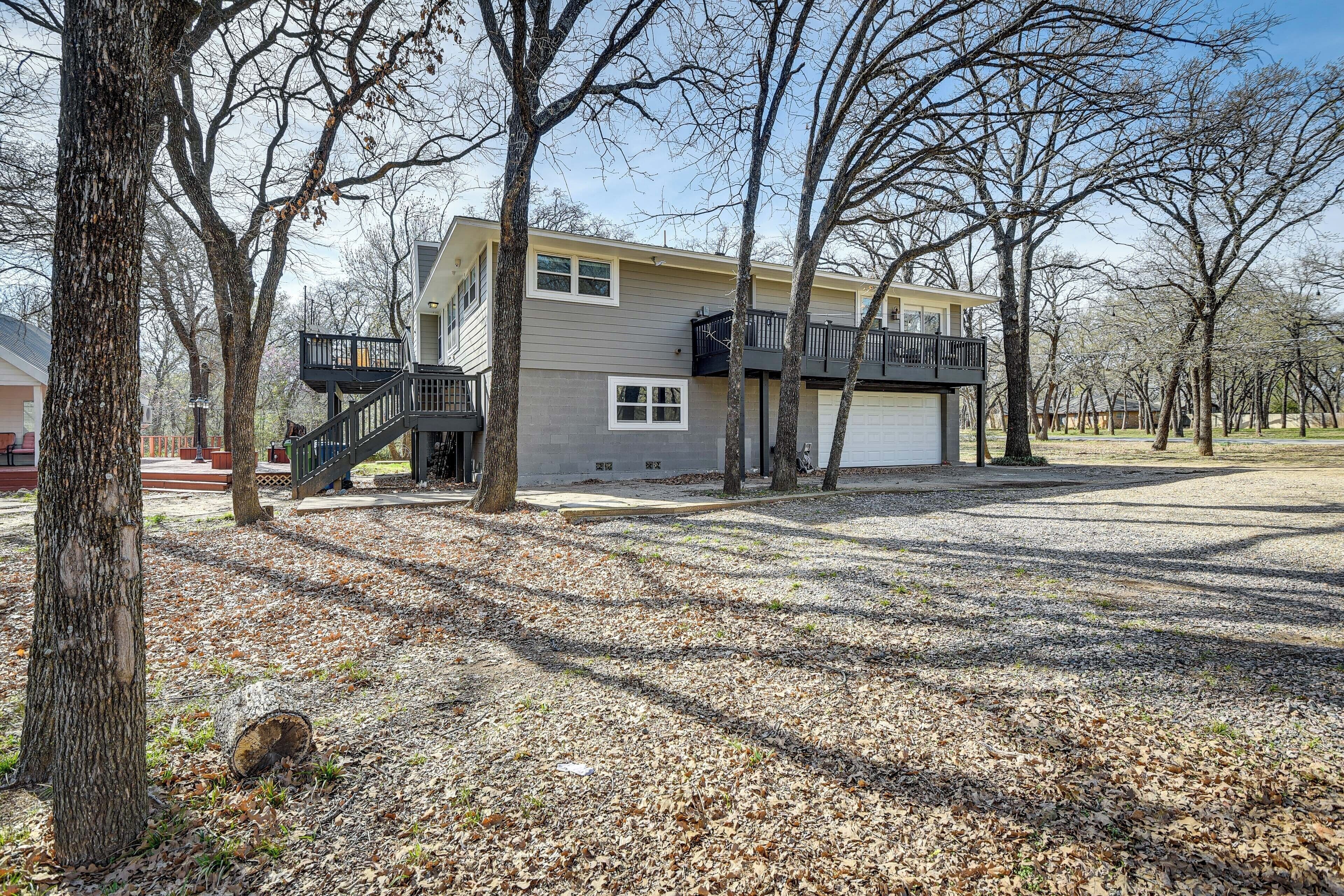 A two-story house with a balcony, a garage, and a driveway.