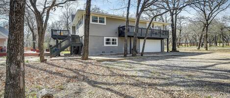 A two-story house with a balcony, a garage, and a driveway.