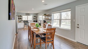 A spacious kitchen with a dining area, wooden flooring, and large windows. - Modern Flower Mound Home < 2 Mi to River Walk (Flower Mound)