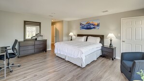 A bedroom with a large bed, a desk, a chair, a dresser, and a painting on the wall. - Modern Flower Mound Home < 2 Mi to River Walk (Flower Mound)