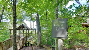 A wooden trail sign in a forested area with a wooden structure nearby. - Scenic Views & Trail Access! Blue Ridge Mtns Condo (Burnsville)