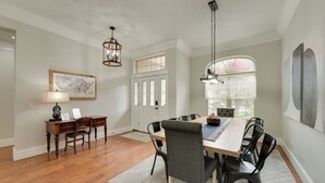 A dining area with a wooden table, black chairs, a chandelier, and a map on the wall. - 4 Mi to Branson Landing: Huge Home w/ Game Room! (Branson)