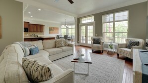 A spacious living room with a large sectional sofa, a coffee table, and a dining area with chairs. - 4 Mi to Branson Landing: Huge Home w/ Game Room! (Branson)