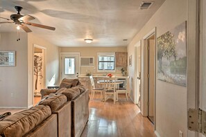 A modern kitchen with a dining area, a ceiling fan, and a view of the outdoors. - Pet-friendly 'shady Oaks' Broken Bow Gem w/ Patio! (Broken Bow)