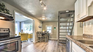 A kitchen with a built-in oven, a dining area with a table and chairs, and a staircase leading to another level. - Osage Beach Family Hideaway on No-wake Cove! (Osage Beach)
