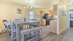 Une cuisine moderne avec des meubles en bois, un îlot central et un coin repas comprenant une table et des chaises.