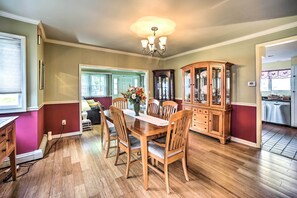 A dining room with a wooden table and chairs, a chandelier, and a china cabinet. - Pet-friendly Latham Retreat ~ 7 Mi to Albany! (Latham)