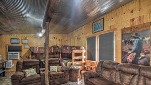 A rustic interior with leather sofas, wooden walls, and a mounted picture of a cowboy. - Pet-friendly Vacation Rental in Braymer! (Braymer)