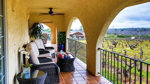 A covered patio with wicker furniture, a ceiling fan, and a view of a vineyard. - Working Vineyard & Private Pool: Villa in Plymouth (Plymouth)