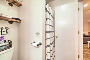 A modern bathroom with a toilet, towel rack, and wall-mounted toilet paper holder.