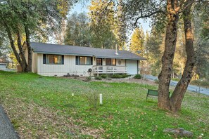 Relax on the front porch, surrounded by a serene lawn and mature trees.