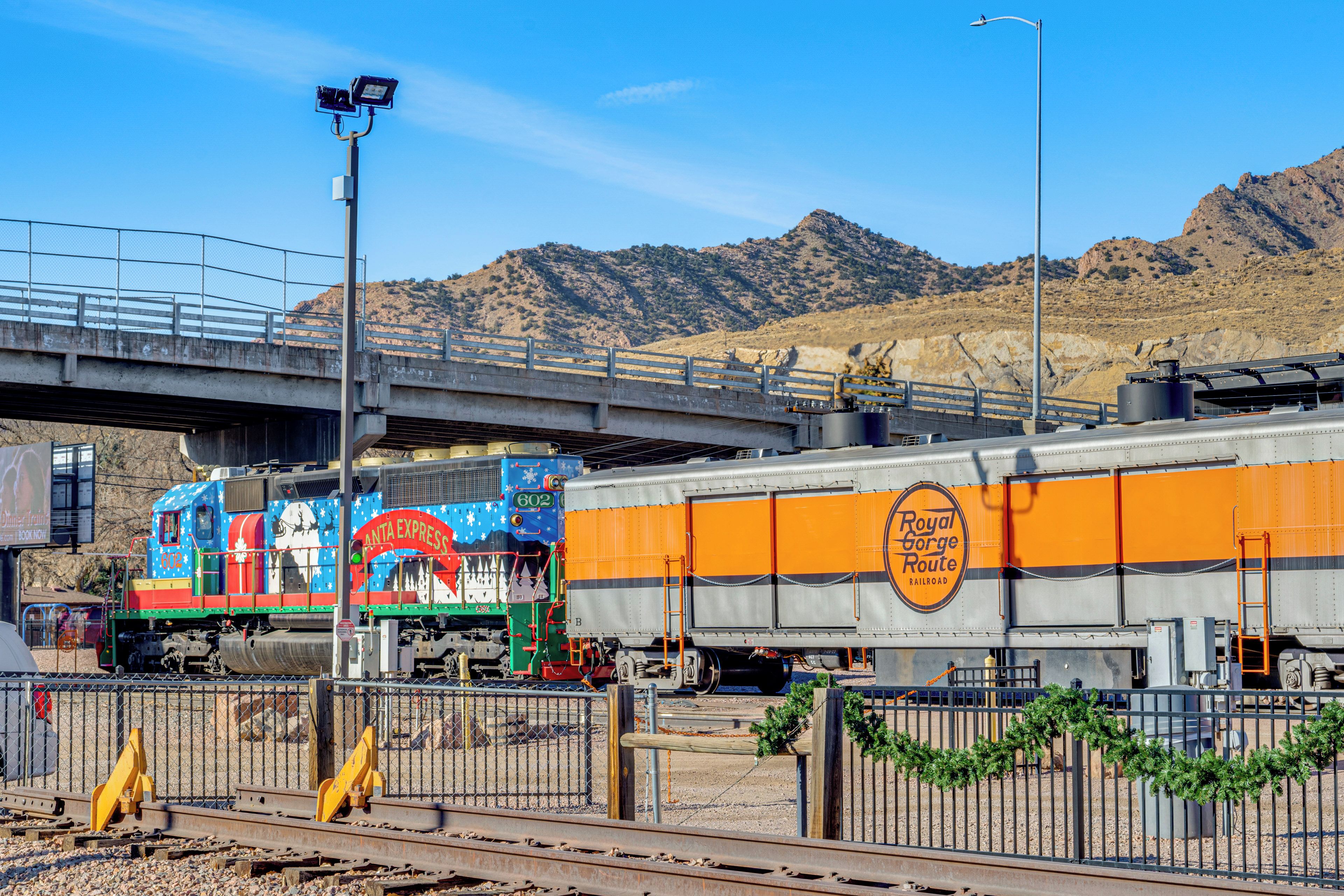 A train with a Santa Express logo passing under a bridge.