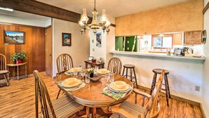 A dining room with a wooden table set for six, surrounded by six chairs. A chandelier hangs from the ceiling, and there are framed pictures on the walls. - Quiet Unit w/ Golf Course & Mtn Views in Graeagle! (Blairsden-Graeagle)