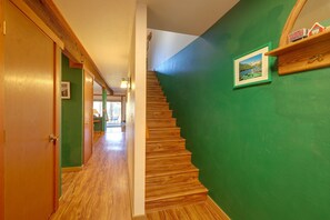 A wooden staircase leading to a second floor with a green wall and a framed picture. - Quiet Unit w/ Golf Course & Mtn Views in Graeagle! (Blairsden-Graeagle)