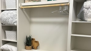 A white closet with shelves, a wooden rod, and a hanging rack. - Relaxing Lubbock Studio ~ 6 Mi to Texas Tech (Lubbock)