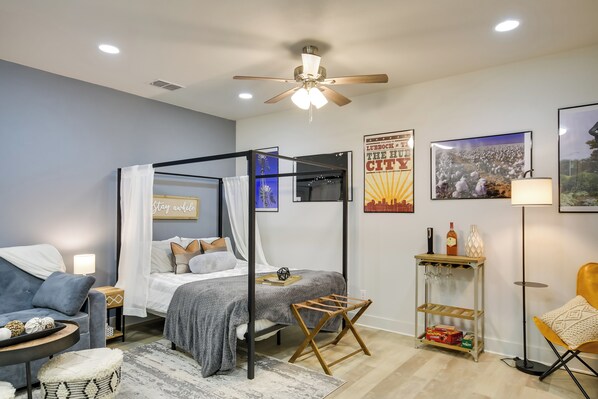 A modern bedroom with a four-poster bed, a sofa, a small table, and a floor lamp. - Relaxing Lubbock Studio ~ 6 Mi to Texas Tech (Lubbock)