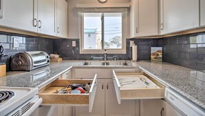 A modern kitchen with white cabinets, a built-in oven, a toaster, and a window with a view of the outside. - Ski, Hike & Unwind: Cozy Carson City Duplex! (Carson City)