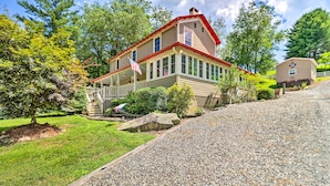 A two-story house with a porch, a flag, and a small shed. - Fish, Float & Relax Fireside: Home Near New River! (Crumpler)