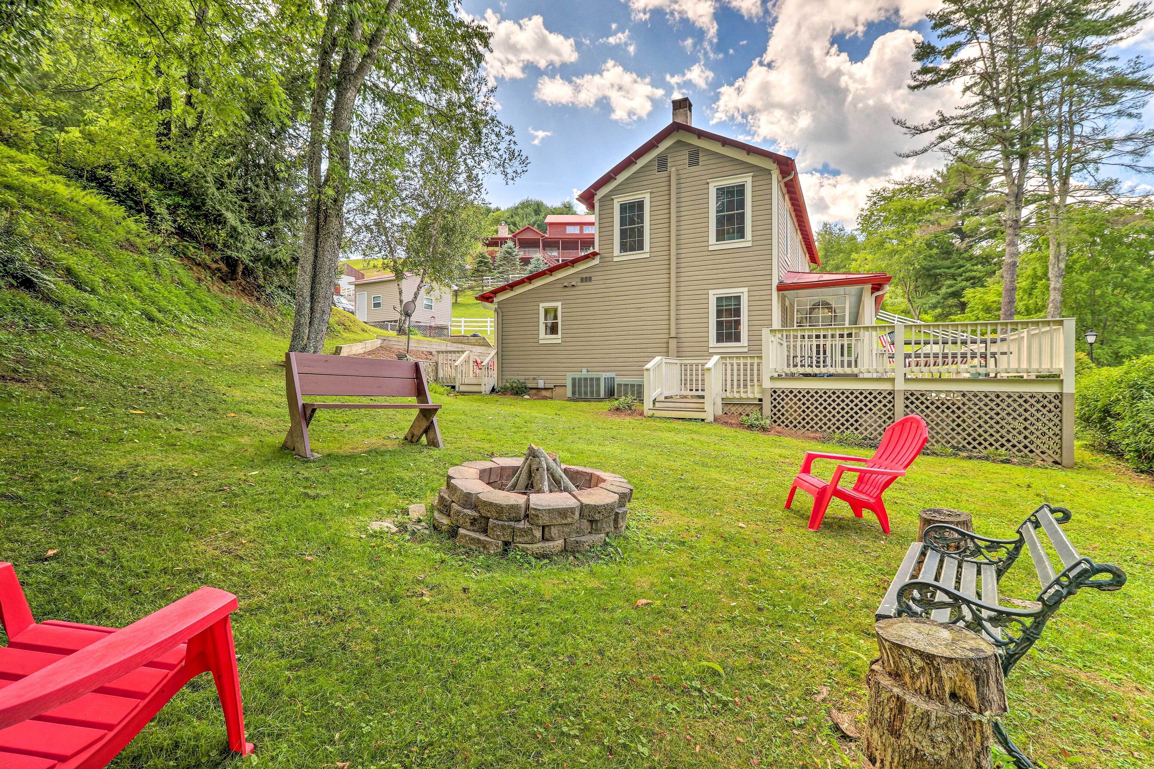 A house with a deck, a fire pit, and outdoor seating.