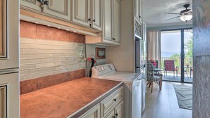 A kitchen with white cabinets, a copper backsplash, and a built-in oven. - Saint Thomas Condo w/ Ocean Views, Walk to Beach! (St. Thomas)