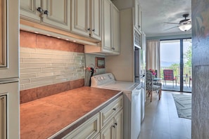 A kitchen with white cabinets, a copper backsplash, and a built-in oven. - Saint Thomas Condo w/ Ocean Views, Walk to Beach! (St. Thomas)
