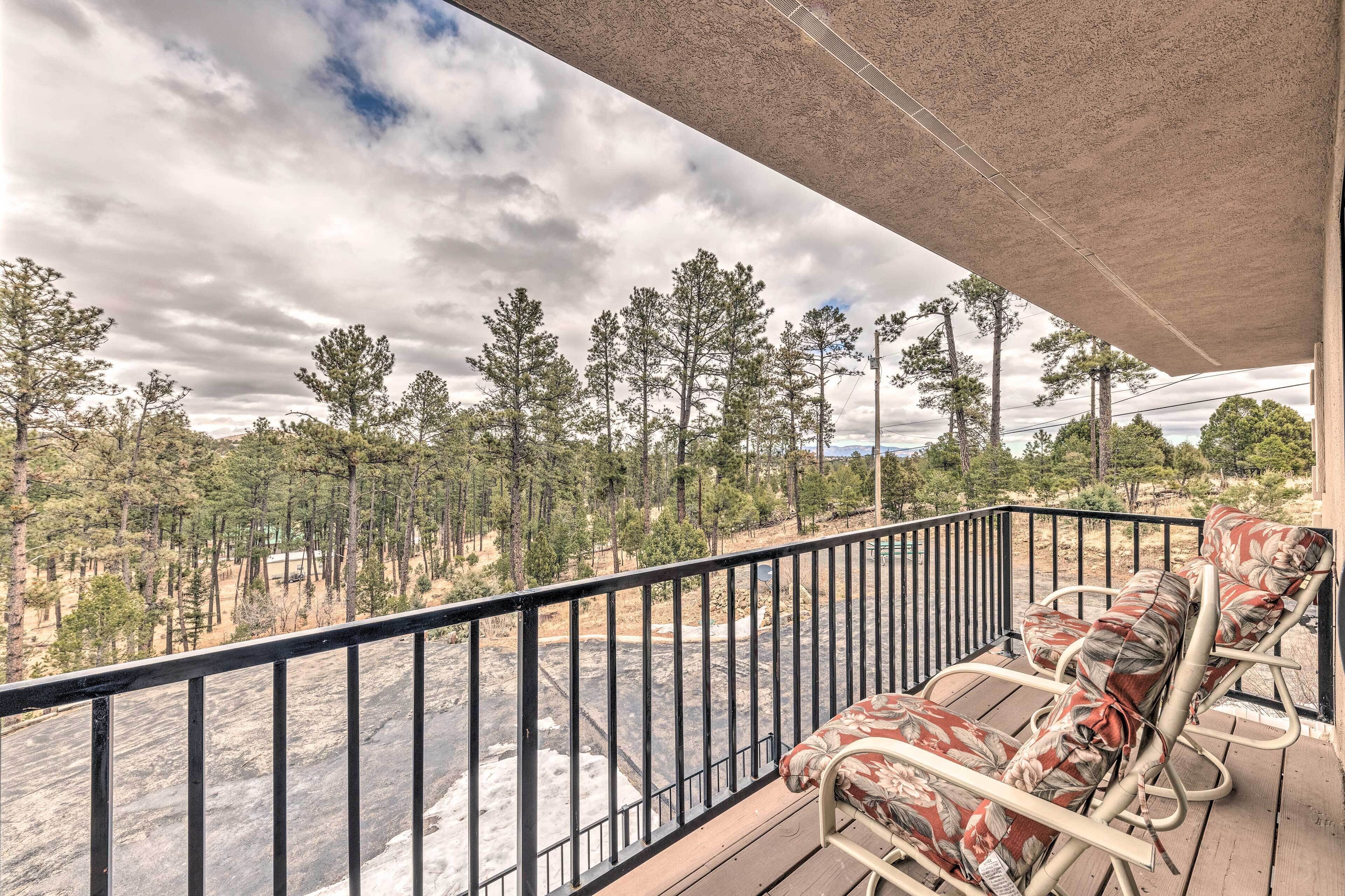 Ein Balkon mit Blick auf einen Wald und einen Fluss.