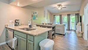 A kitchen with granite countertops, a dishwasher, and a dining area with a table and chairs. - Reeds Spring Condo Near Aquarium at the Boardwalk! (Branson West)