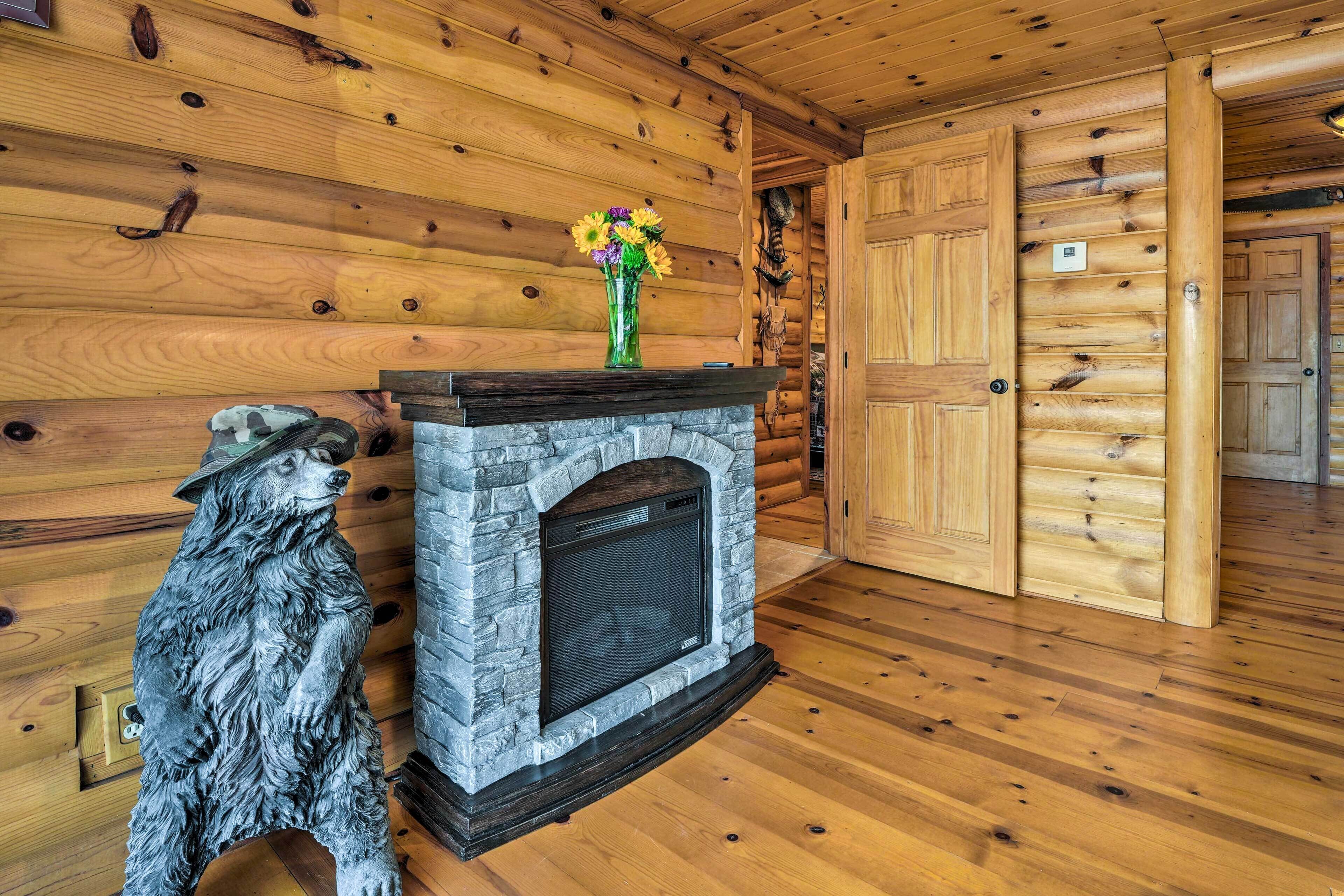 Ein Blockhaus-Innenraum mit Kamin aus Stein, Holzwänden und Holzboden.
