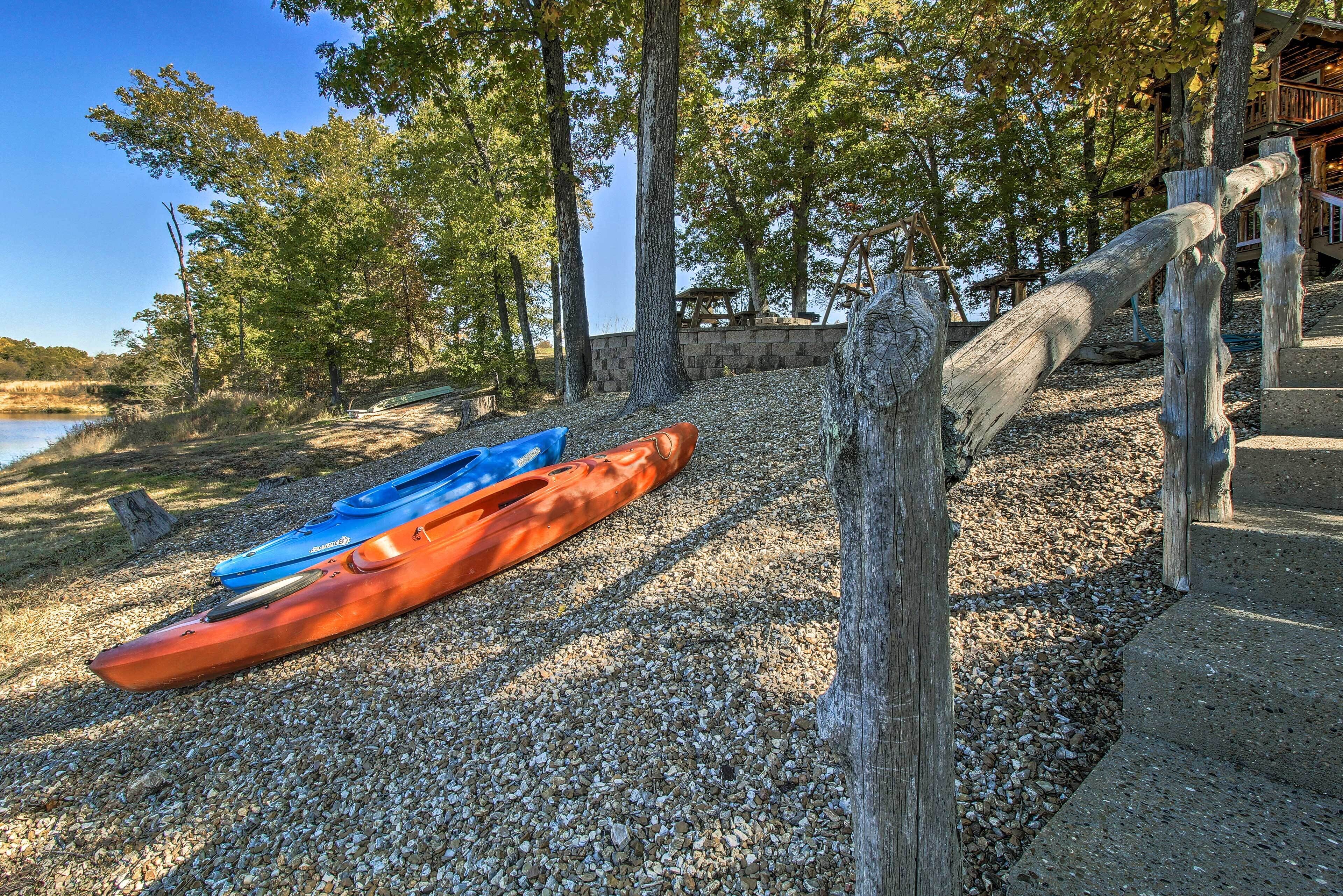 A gravel path leading to a wooden deck with kayaks.