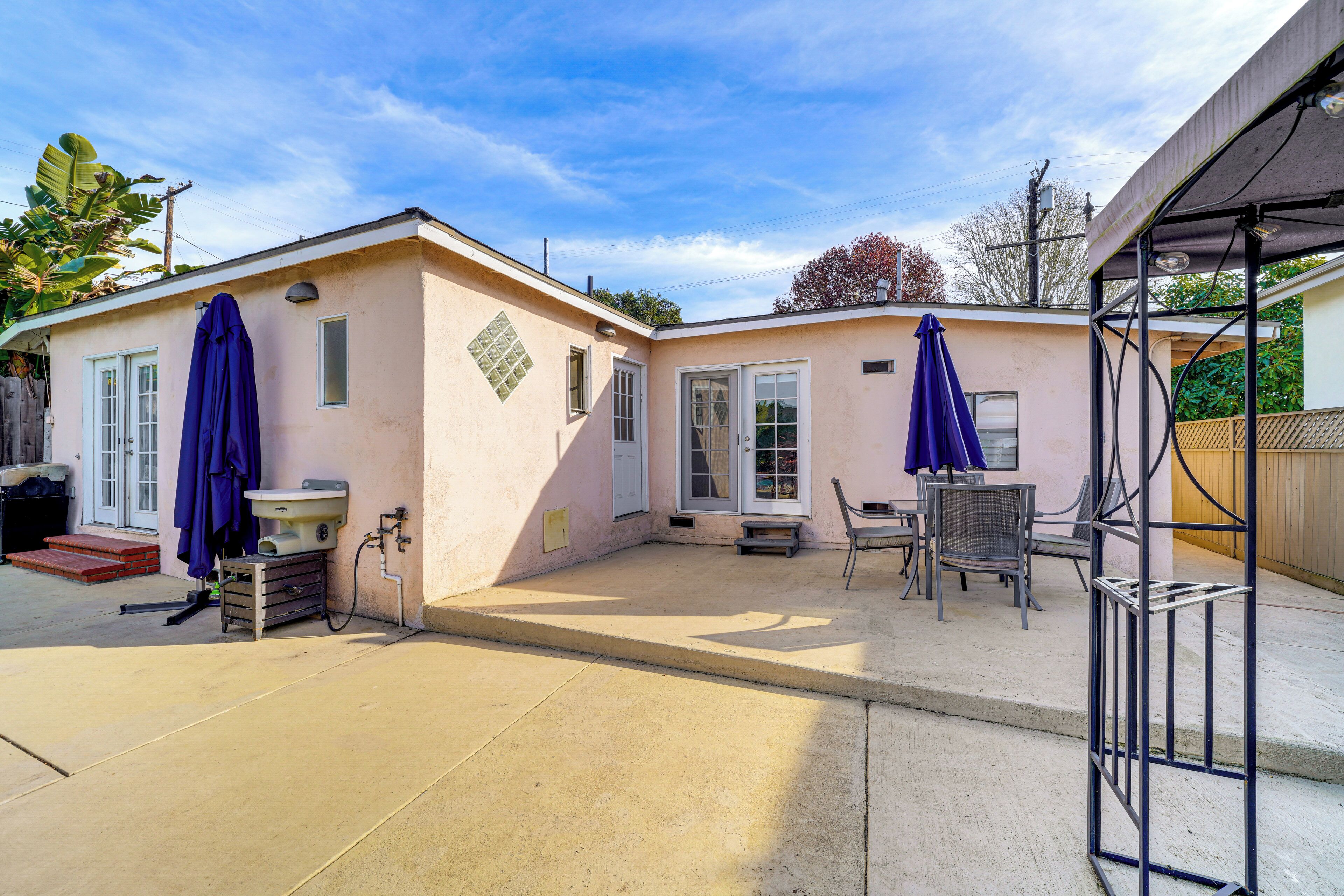 Une maison à deux étages dotée d’un patio couvert, d’un petit porche et d’un garage.