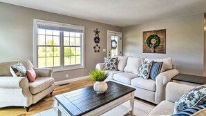 A living room with two sofas, a coffee table, and a large window. - Secluded Retreat on 2 Acres Near Dale Hollow Lake! (Burkesville)