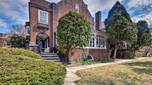 A brick building with a large tree in front, a pathway, and a grassy area. - Walk to Shops, Dining & City Park: Reading Apt (Reading)