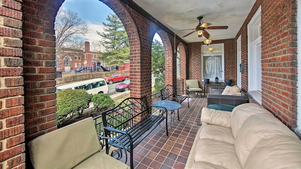 A covered patio with brick walls, a sofa, and a table. - Walk to Shops, Dining & City Park: Reading Apt (Reading)