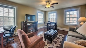 A living room with a fireplace, a ceiling fan, and a TV. - Walk to Shops, Dining & City Park: Reading Apt (Reading)