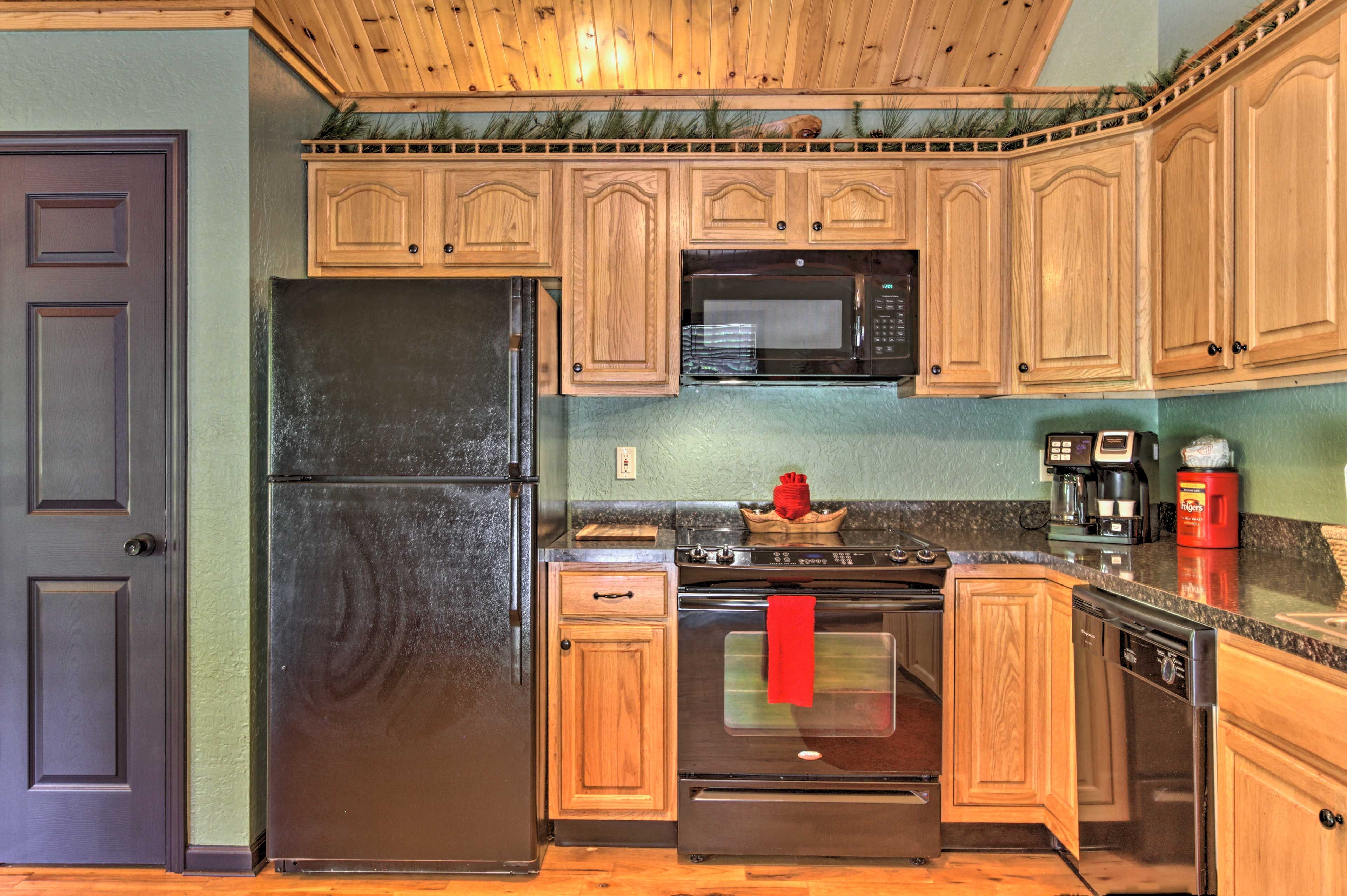 A kitchen with wooden cabinets, a refrigerator, a microwave, a stove, and a dishwasher.