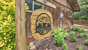 A wooden cabin with a sign that reads "Secluded River Cottage." - Secluded Stanardsville Cabin w/ 10 Acres & Hot Tub (Stanardsville)