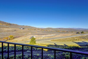 A rural landscape with a road curving through a hilly area, a small settlement with houses, and a clear blue sky. - Mountainside Home: Stunning Views in Granby Ranch! (Granby)