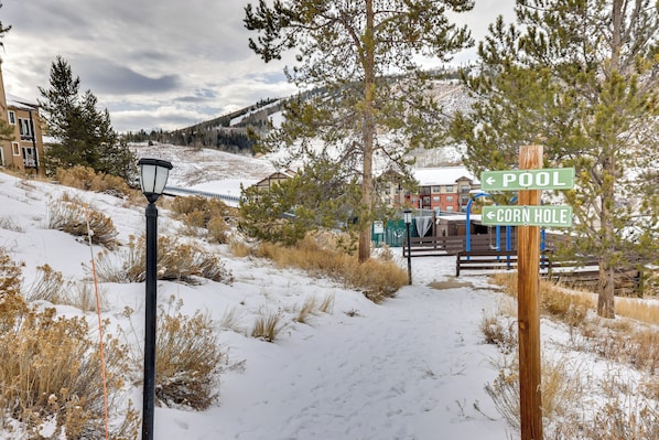 A snowy landscape with a signpost indicating directions to 'Pool' and 'Corn Hole'.