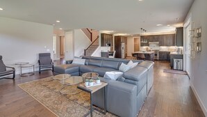 A spacious living room with a gray sectional sofa, a coffee table, and a rug. - Spacious Carnation Home w/ Grill & Large Yard (Carnation)