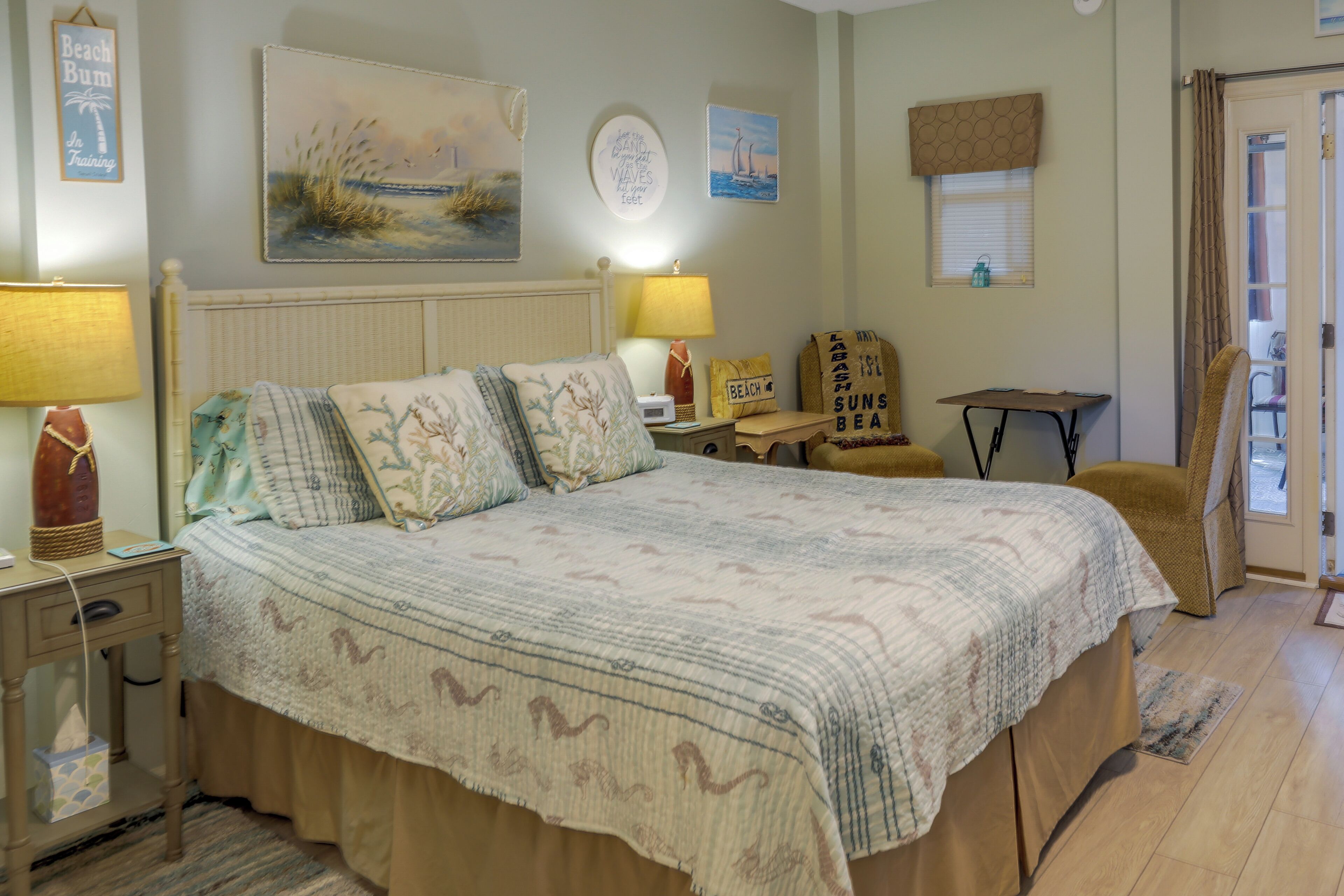 Ein Schlafzimmer mit Bett, Nachttischen, einem Sessel und Wanddekorationen.