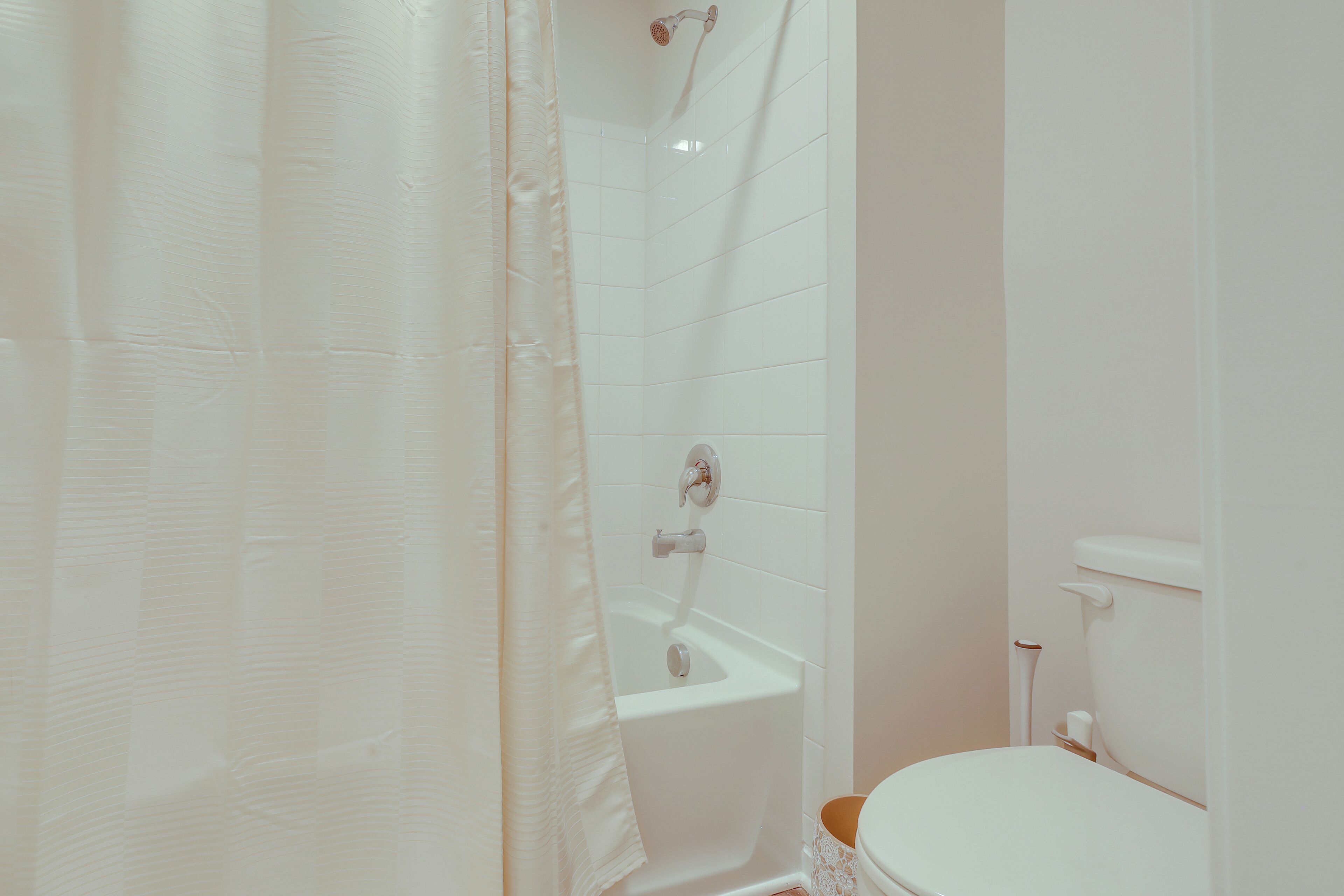 Une salle de bain avec une baignoire, des toilettes et un rideau de douche.