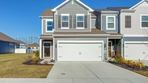 A two-story residential house with a garage, a front yard with a lawn and shrubs, and a clear blue sky. - 3 Mi to Bethany Beach: 'the Chiefs Quarters' Home (Ocean View)