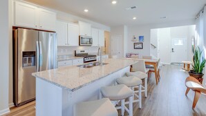 A modern kitchen with white cabinets, stainless steel appliances, and a granite countertop. - 3 Mi to Bethany Beach: 'the Chiefs Quarters' Home (Ocean View)