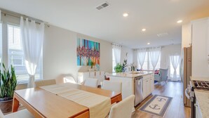 A modern kitchen with white cabinets, a wooden dining table, and a kitchen island. - 3 Mi to Bethany Beach: 'the Chiefs Quarters' Home (Ocean View)